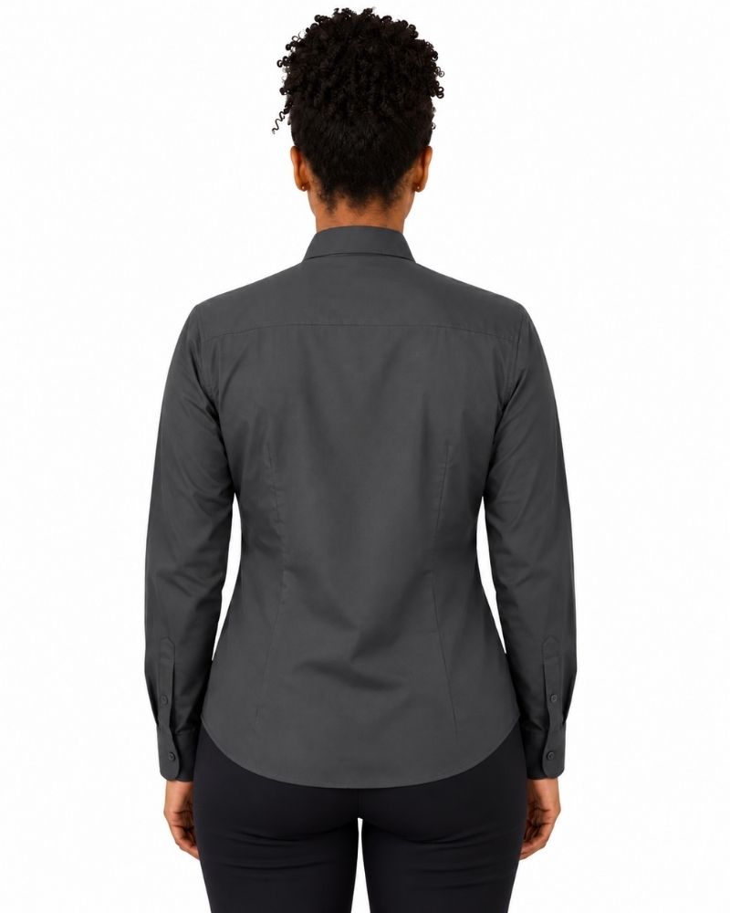 A woman viewed from the back wearing a dark charcoal gray long-sleeve clerical shirt and black pants, set against a plain white background.
