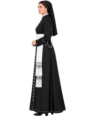 A woman modeling a  Black Clergy Cassock with a matching black veil, white apron panel, white trim, and black shoes against a plain white background.