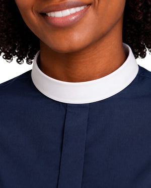 Close-up of a women wearing a navy blue clerical shirt, showing the neck, lower face, and collar detail against a light background.