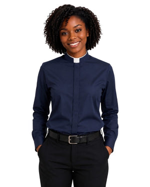 A smiling woman with curly black hair wearing a navy blue long-sleeve clerical shirt with a white collar, paired with black trousers and a black belt, against a plain white background.