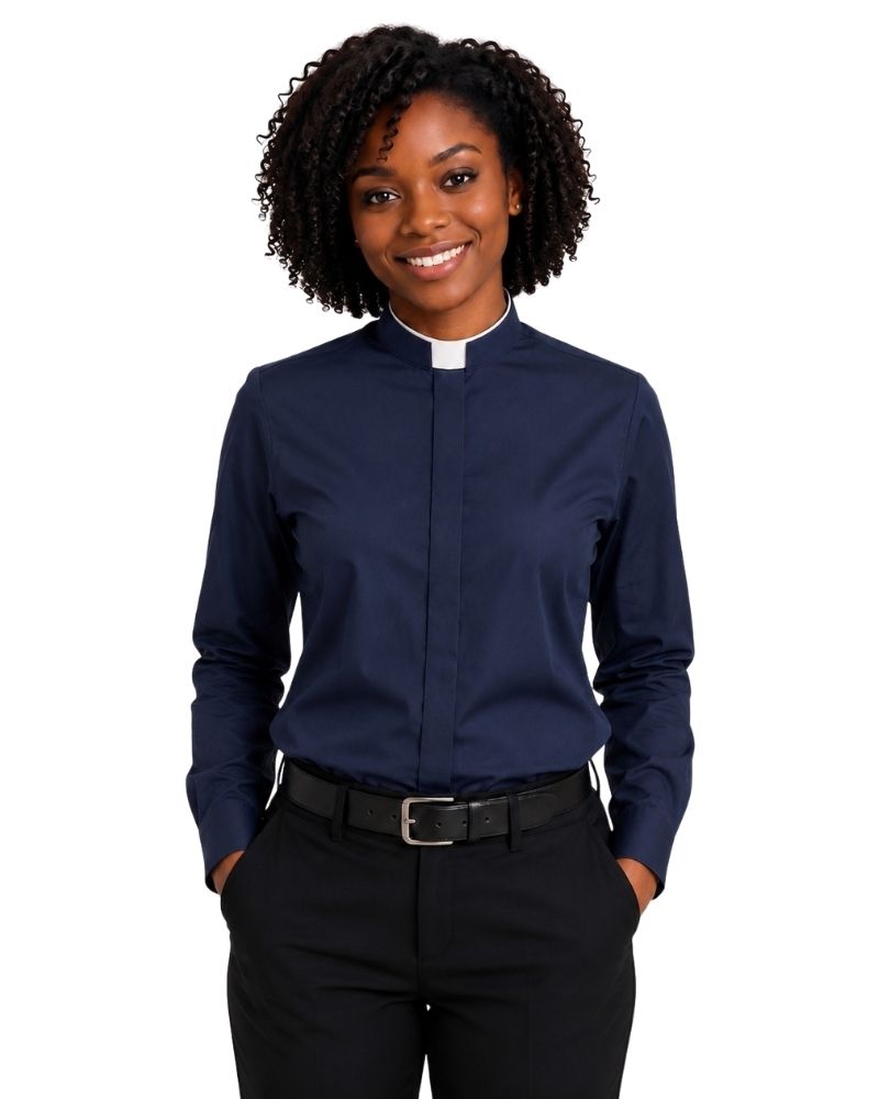 A smiling woman with curly black hair wearing a navy blue long-sleeve clerical shirt with a white collar, paired with black trousers and a black belt, against a plain white background.