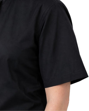 Close-up of a women wearing a black short-sleeve clerical shirt against a plain white background.