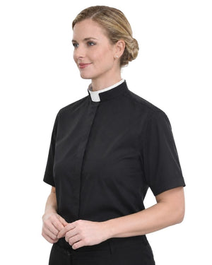A woman wearing a black short-sleeve clerical shirt with a white collar, shown from the waist up against a plain white background.