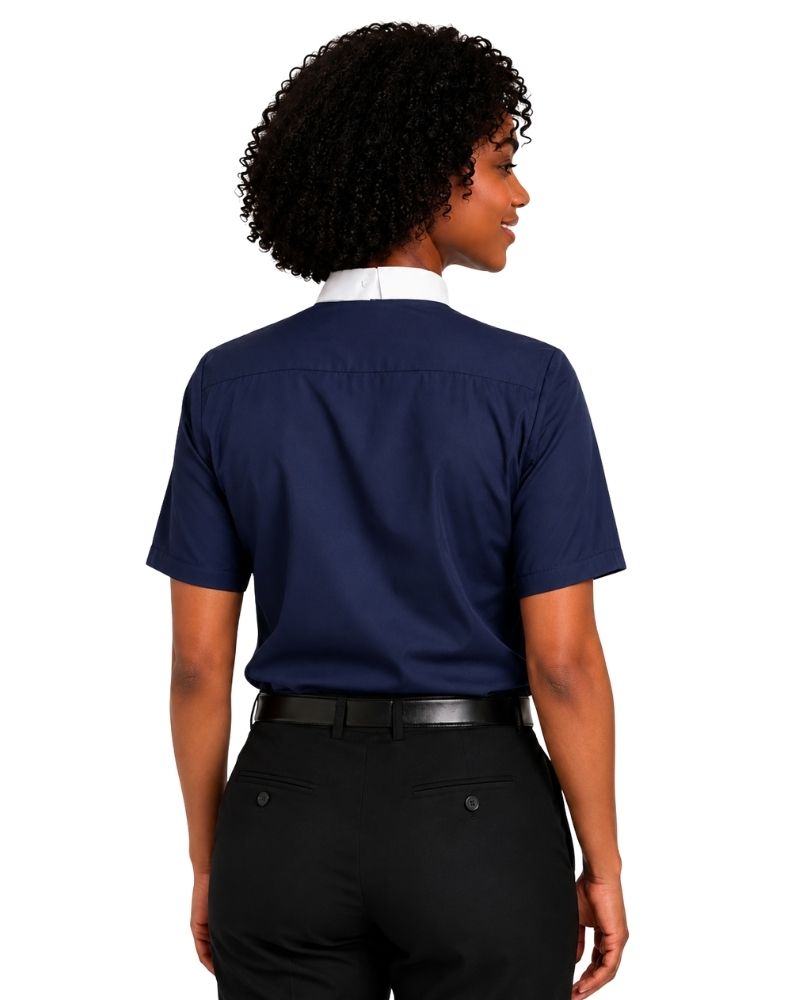 A woman shown from the back wearing a navy blue short-sleeve clerical shirt tucked into black pants, against a plain white background.