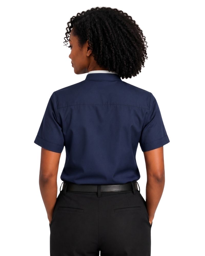 A woman shown from the back wearing a navy blue short-sleeve clerical shirt tucked into black pants, against a plain white background.