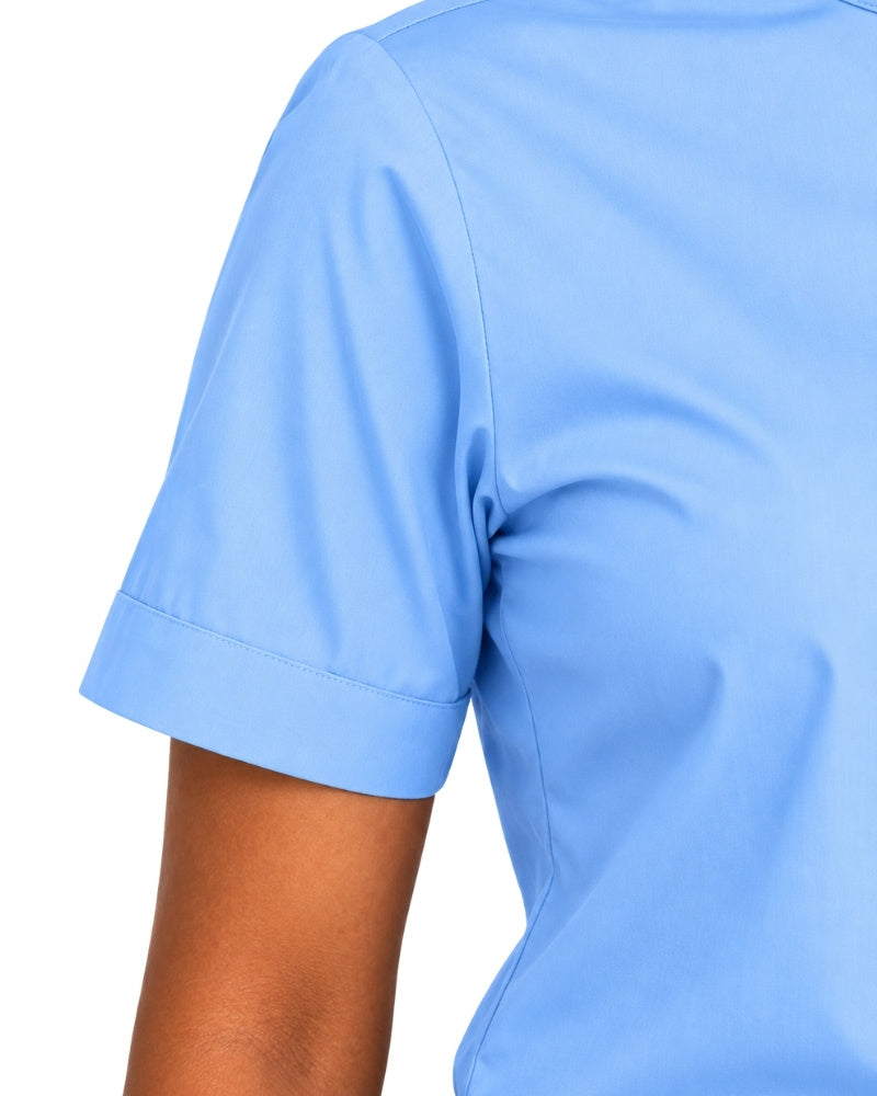 Close-up of a woman wearing a light blue short-sleeve clerical shirt, showing the sleeve cuff and shoulder area against a plain white background.