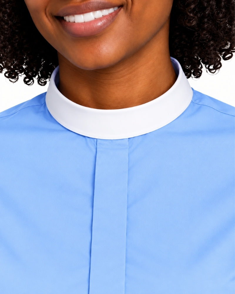 Close-up of a woman wearing a light blue clerical shirt with a contrasting white high stand collar, cropped from the mouth down against a plain white background.