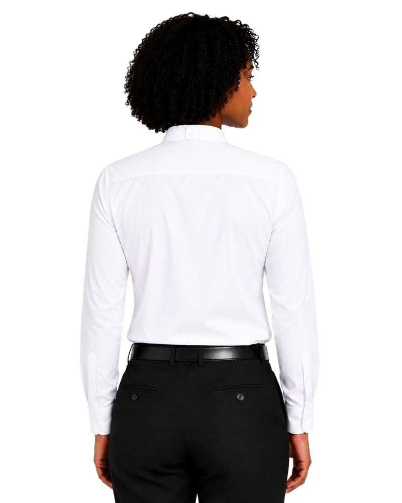 A woman shown from the back wearing a white long-sleeve clerical shirt tucked into black trousers with a black belt, against a plain white background.