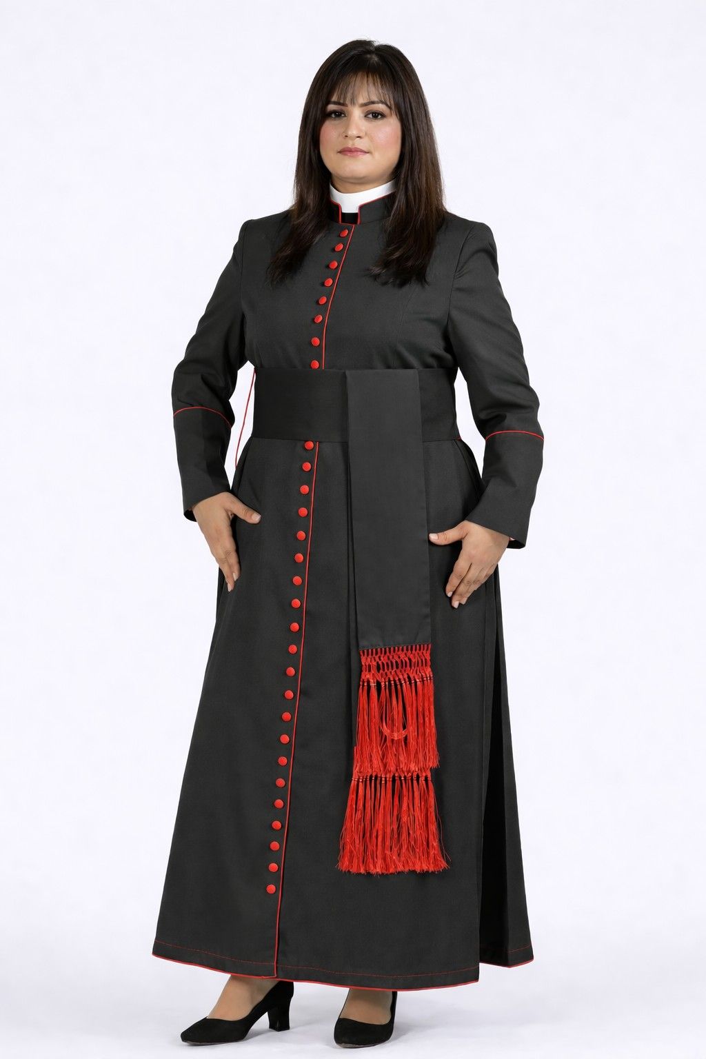Woman wearing a long black coat with red buttons and fringes on a white background