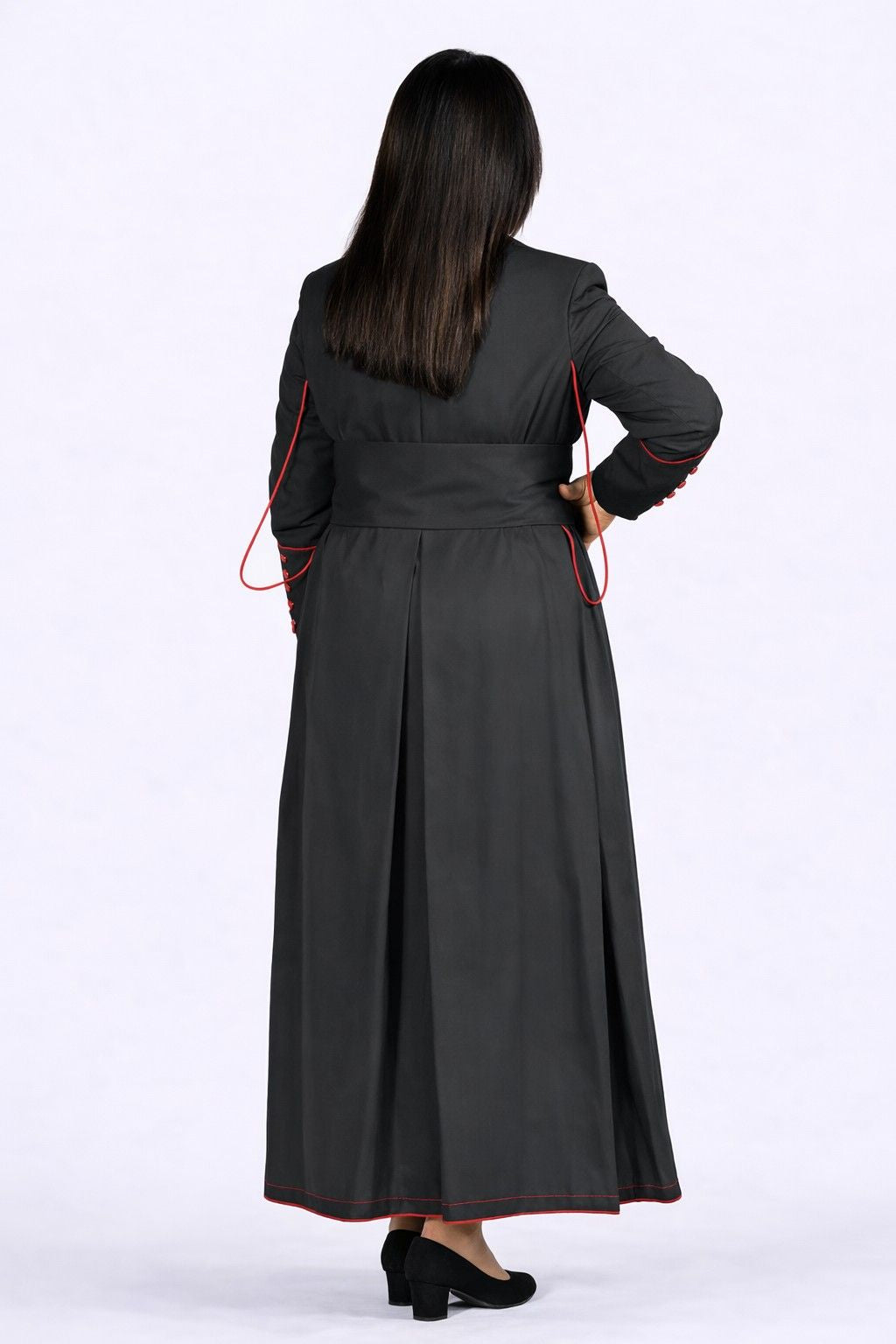 Woman wearing a long black dress with red accents on a white background
