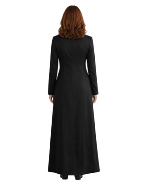 A woman with red hair wearing a long black cassock photographed against a plain white background.