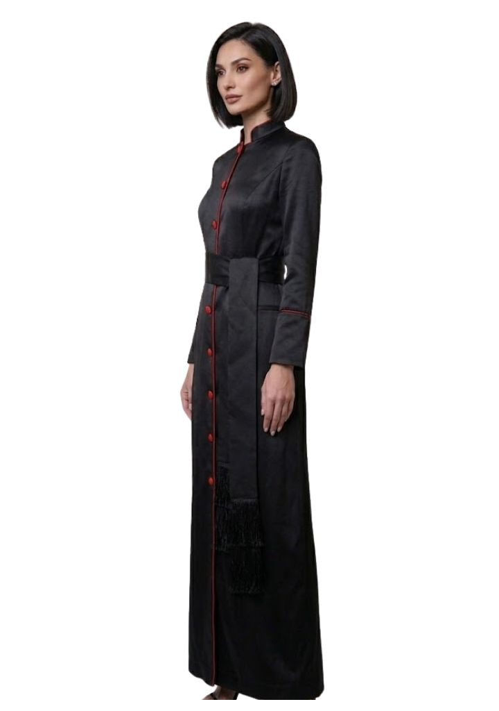 Woman wearing a long black dress with red buttons on a white background