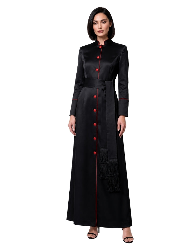 A woman modeling a long black satin-like robe with red button accents and red piping details, photographed against a plain white background.