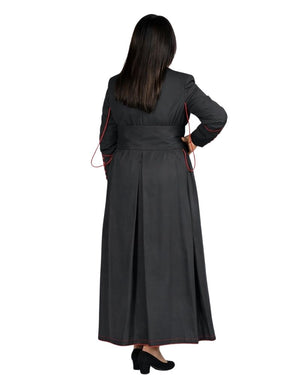 A woman shown from the back wearing a long cassock with thin red piping along the sleeves and side seams, photographed against a plain white background.