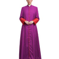 A woman modeling a long magenta-purple cassock with red cuffs and a red button placket over a white collar, photographed against a plain white background.