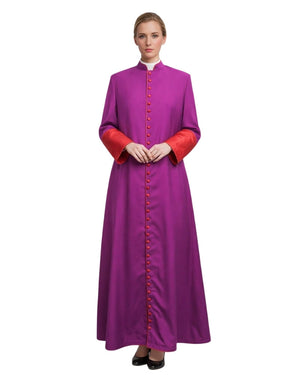 A woman modeling a long magenta-purple cassock with red cuffs and a red button placket over a white collar, photographed against a plain white background.