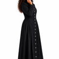 Woman wearing a long black robe with button details on a white background
