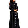 A woman modeling a long black cassock with a high collar, front button closure, and long sleeves, shown against a plain white background.