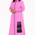 Woman wearing a pink dress with black buttons and fringes on a white background
