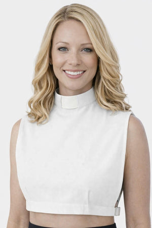 Woman wearing a white sleeveless top against a plain background