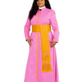 A woman modeling a bright pink cassock with gold trim, gold buttons, and a gold fringe detail on the front, paired with a white collar and black shoes, against a plain white background.