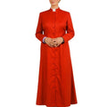 A woman modeling a long-sleeved red clerical robe with a white collar, standing against a plain white background.