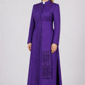 Woman wearing a long purple dress with a white collar on a white background
