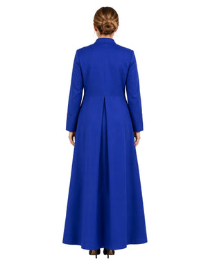 A woman viewed from the back wearing a long royal blue cassock with long sleeves, a high collar, and a gathered waist seam, photographed against a plain white background.