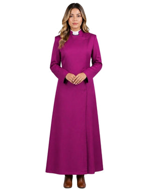 A woman wearing a long magenta-purple clerical robe with a white collar, standing against a white background.
