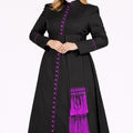 Woman wearing a black robe with purple accents on a white background