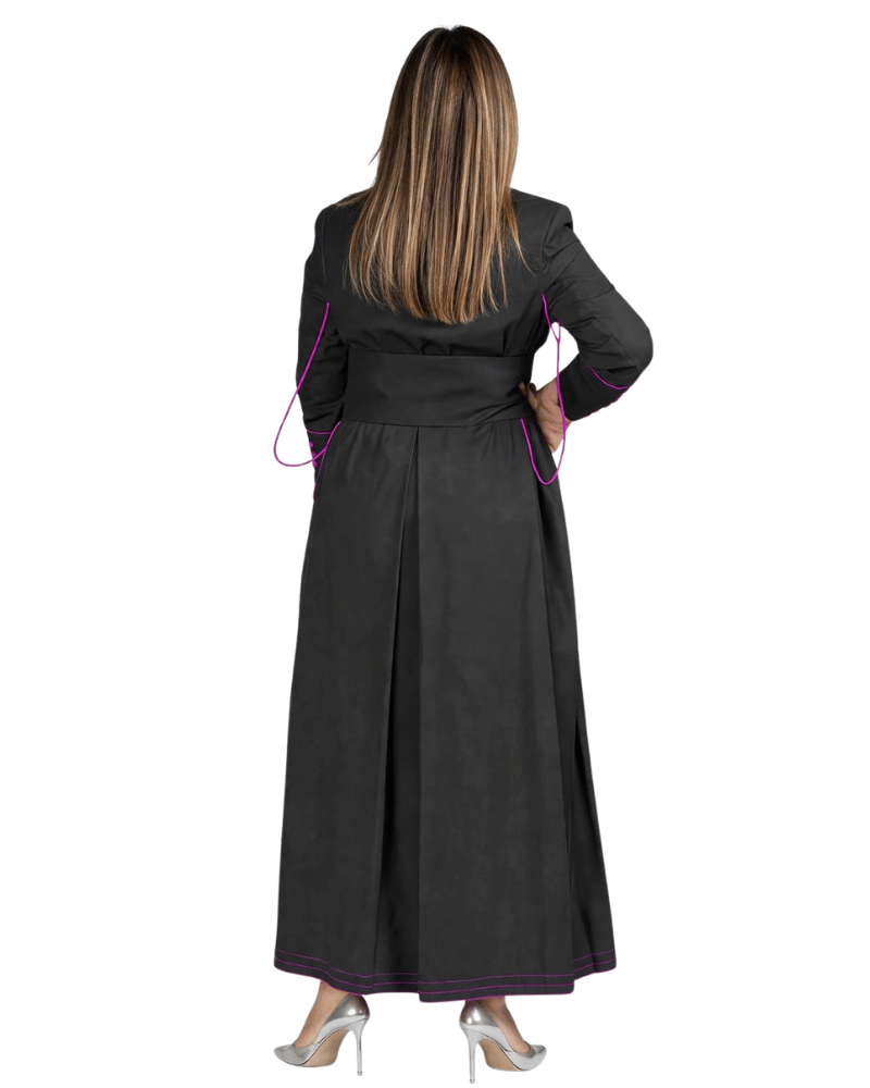 A woman viewed from the back wearing a long black cassock with purple piping details along the sleeves and hem, paired with silver high heels, against a plain white background.