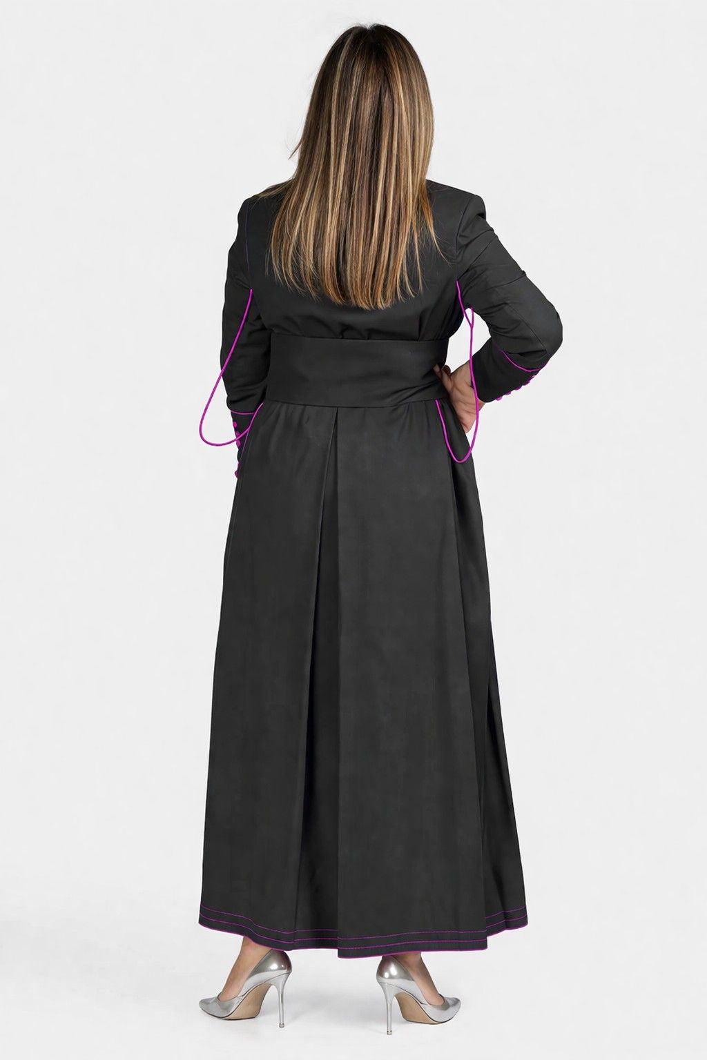 Woman wearing a black robe with pink accents from behind on a white background