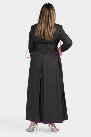 Woman wearing a black robe with pink accents from behind on a white background