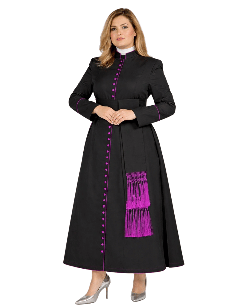 A woman modeling a long black dress with bright purple trim, purple button accents down the front, and a purple fringe detail on the sash, paired with a white collar and silver heels, against a plain white background.