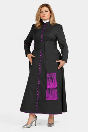 Woman wearing a black robe with purple accents and a purple stole on a white background
