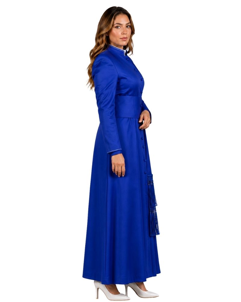 A woman modeling a long royal blue cassock with long sleeves, a high collar, and a fitted waist, shown in profile against a plain white background.
