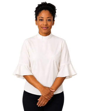 Woman wearing a off white clergy shirt with a white collar on a white background.