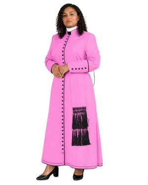 A woman modeling a bright pink cassock with black fringe and black decorative buttons, styled with a white collar and black heels, against a plain white background.