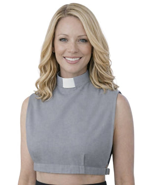 A smiling woman wearing a gray sleeveless mock-neck top with a white clerical collar, shown against a plain white background.