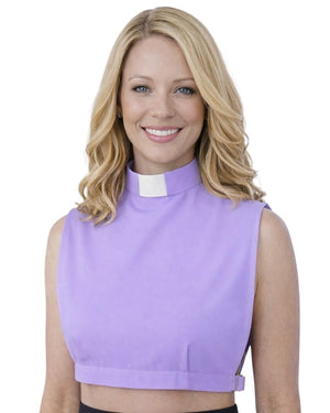 A smiling woman wearing a lavender sleeveless mock-neck top with a white clerical collar, shown against a plain white background.