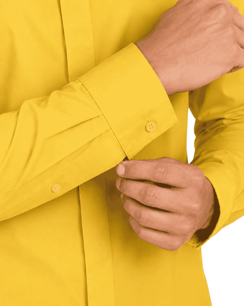 Close-up of a man wearing a bright yellow long-sleeve button-up clerical shirt, adjusting the cuff with one hand while the other hand rests near the pocket.