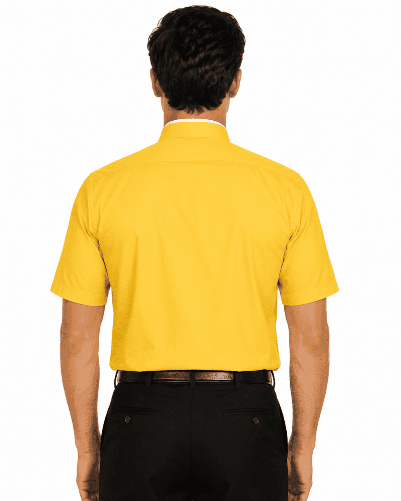 A man viewed from the back wearing a bright yellow short-sleeve clerical shirt and black trousers, standing against a plain white background.