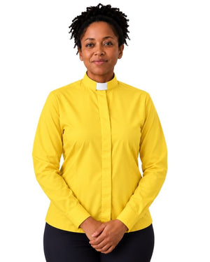 A woman wearing a bright yellow long-sleeve clerical shirt with a white collar tab, paired with black pants, standing against a plain white background.