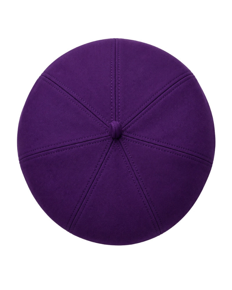 A top-down view of a clergy zucchetto cap with a suede-like texture and stitched panel seams, isolated on a white background.