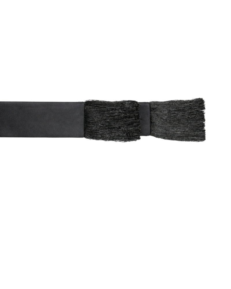A close-up of a black sash with a textured, fringed end on a plain white background.